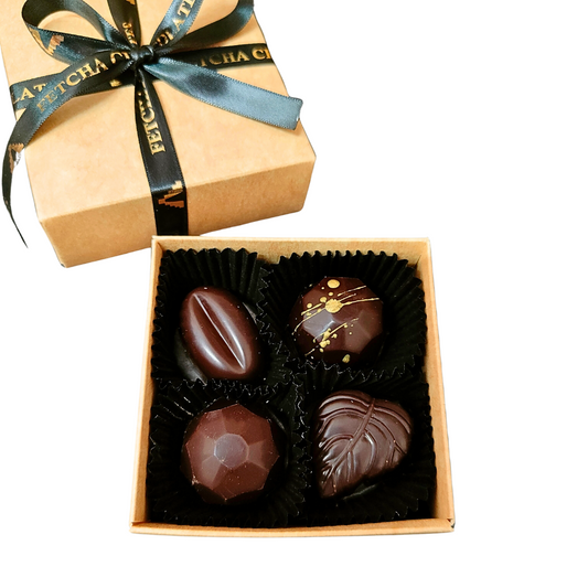 Image shows Fetcha Chocolates handmade box of four dark filled chocolates, which are vegan, dairy free, gluten free and soy free and come in plastic-free packaging.