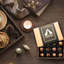 Image shows Fetcha Chocolates handmade Classic collection (a mix of milk, dark and white chocolate) which are vegan, dairy free, gluten free and soy free and come in plastic-free packaging. Image shows twelve chocolates sitting inside a kraft box with black and gold branding, sitting on a table next to a candles, books, throw and coffee cup.