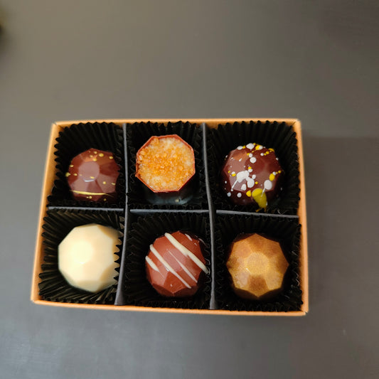 Image shows Fetcha Chocolates handmade Shop Favourites collection of filled chocolates, which are vegan, dairy free, gluten free and soy free and come in plastic-free packaging. Image shows a box of six.