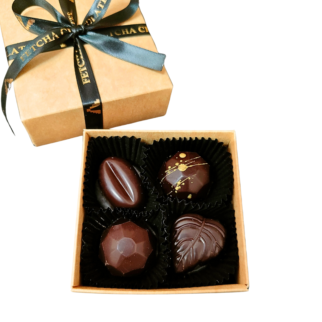 Image shows Fetcha Chocolates handmade box of four dark filled chocolates, which are vegan, dairy free, gluten free and soy free and come in plastic-free packaging. 