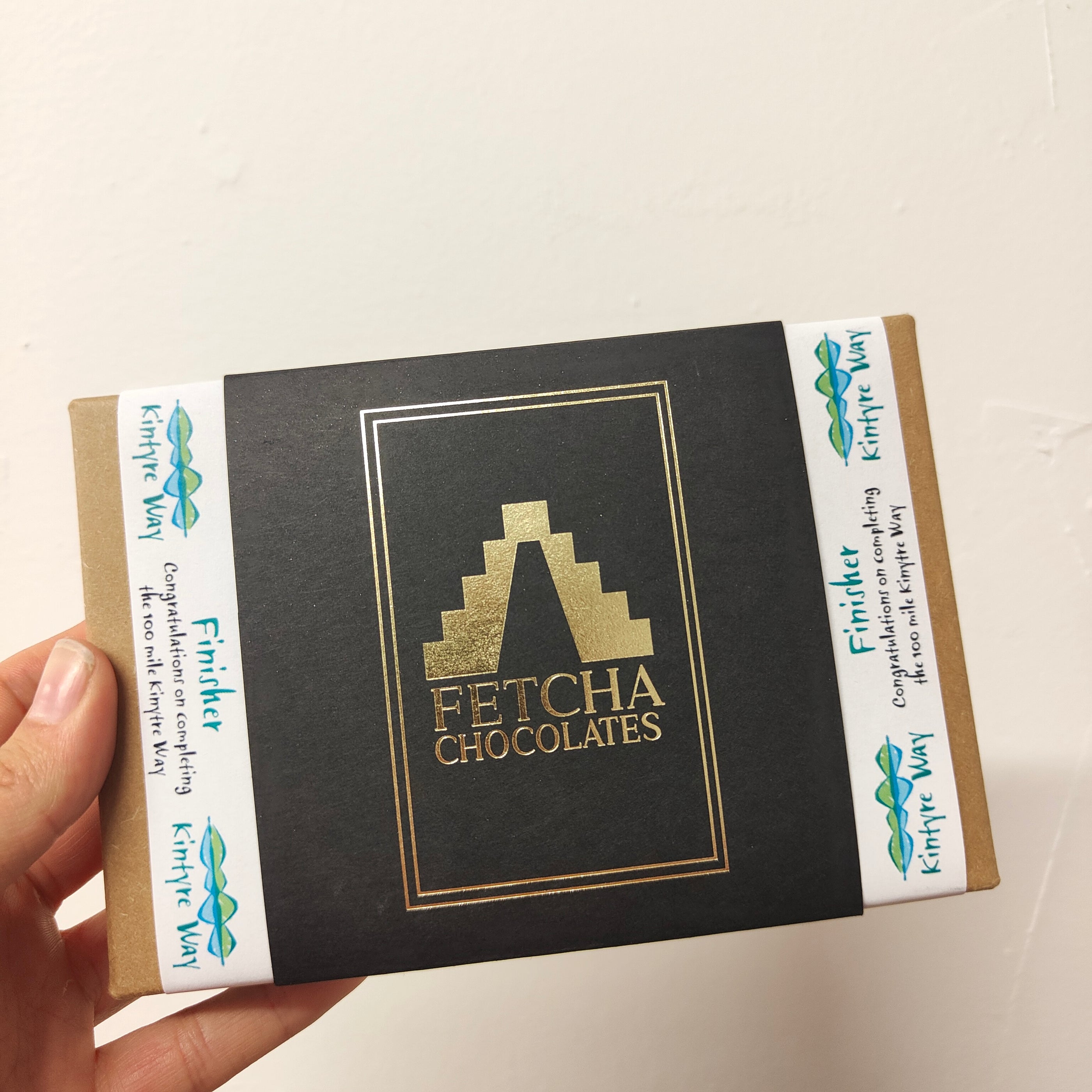 Image shows Kintyre way finisher box of vegan, dairy free and gluten free chocolates from Fetcha Chocolates