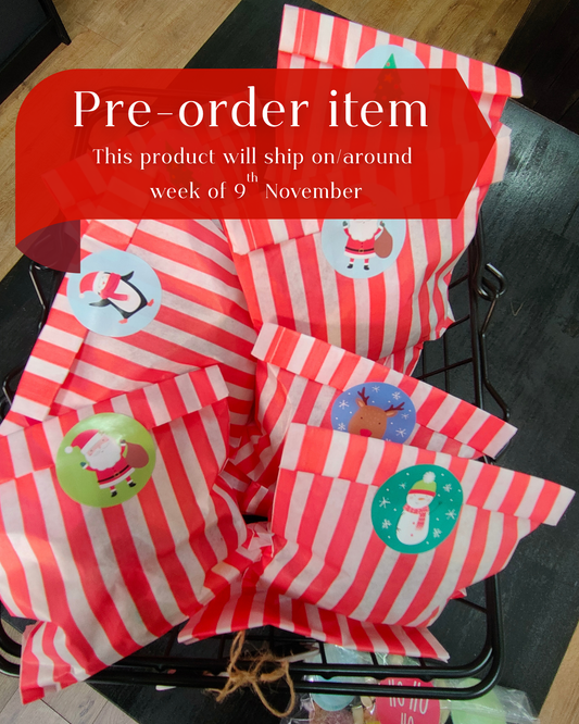 Red and white striped bags with Christmas-themed stickers on a black surface, with text indicating a pre-order item.