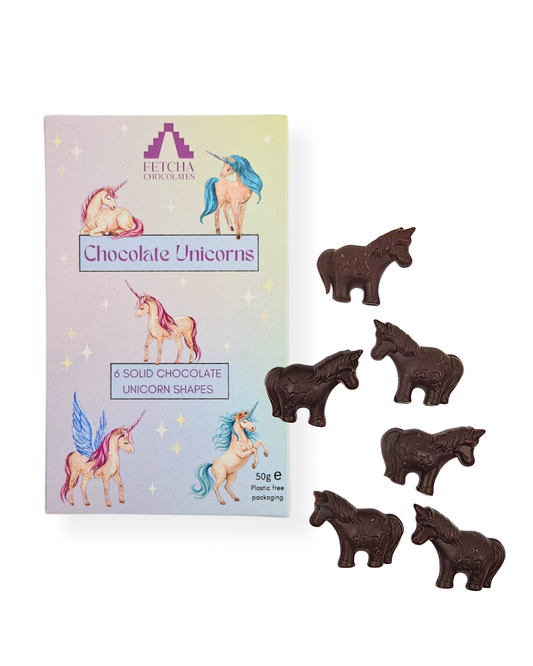 Box of vegan chocolate unicorn shapes with individual chocolate unicorns on a white background