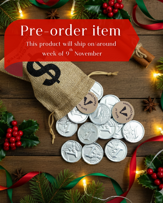 Pre-order item with white chocolate foil wrapped vegan coins, bag, and festive decorations on a wooden surface.