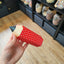Image shows a hand holding a pencil shaped gift box, being sold by Fetcha Chocolates