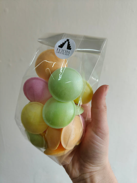 Image shows a clear packet of colourful flying saucer sweets, being sold by Fetcha Chocolates