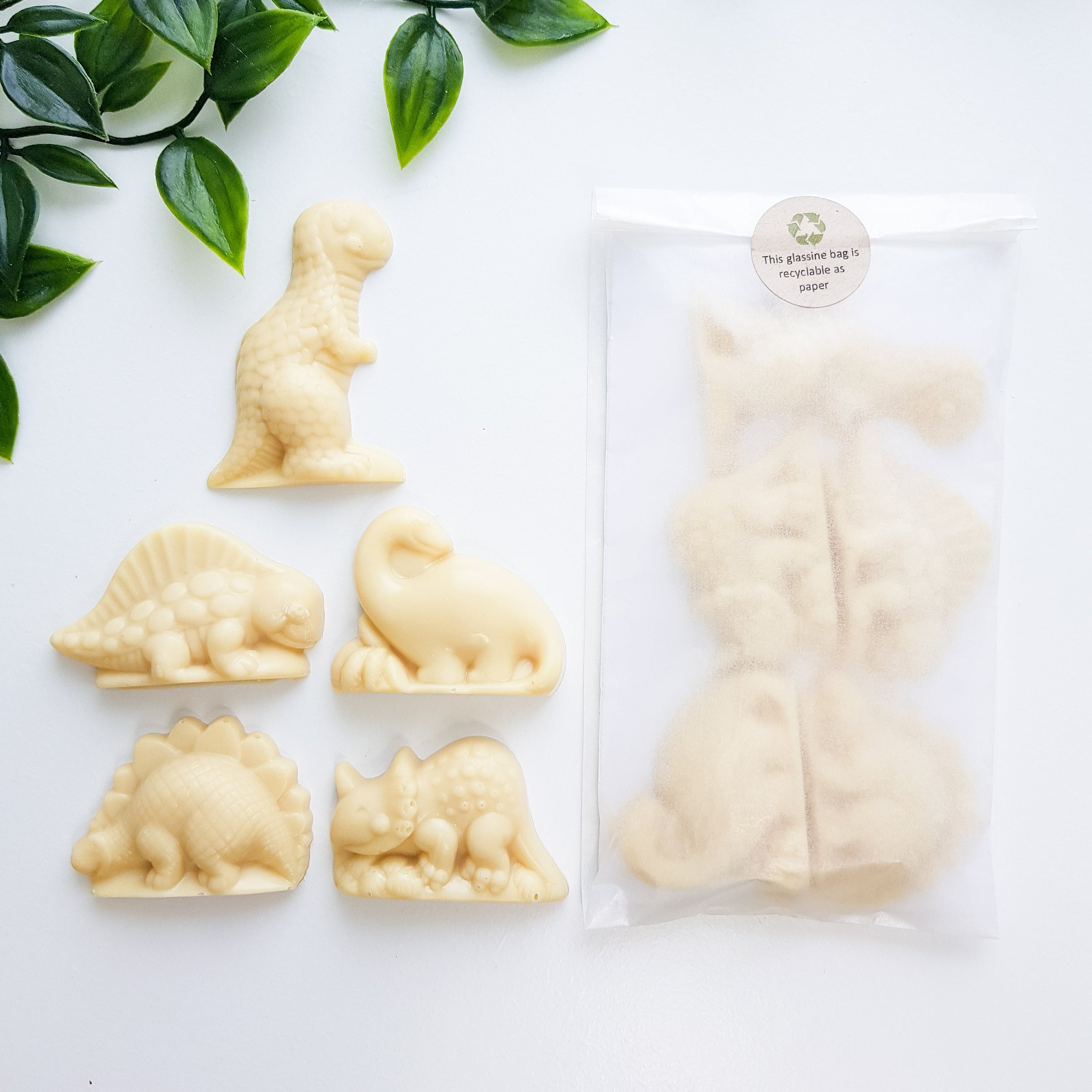 Image shows Fetcha Chocolates handmade solid white chocoloate 3D dinosaurs in a pack of five with box. They are vegan, dairy free, gluten free and soy free and come in plastic-free packaging. 