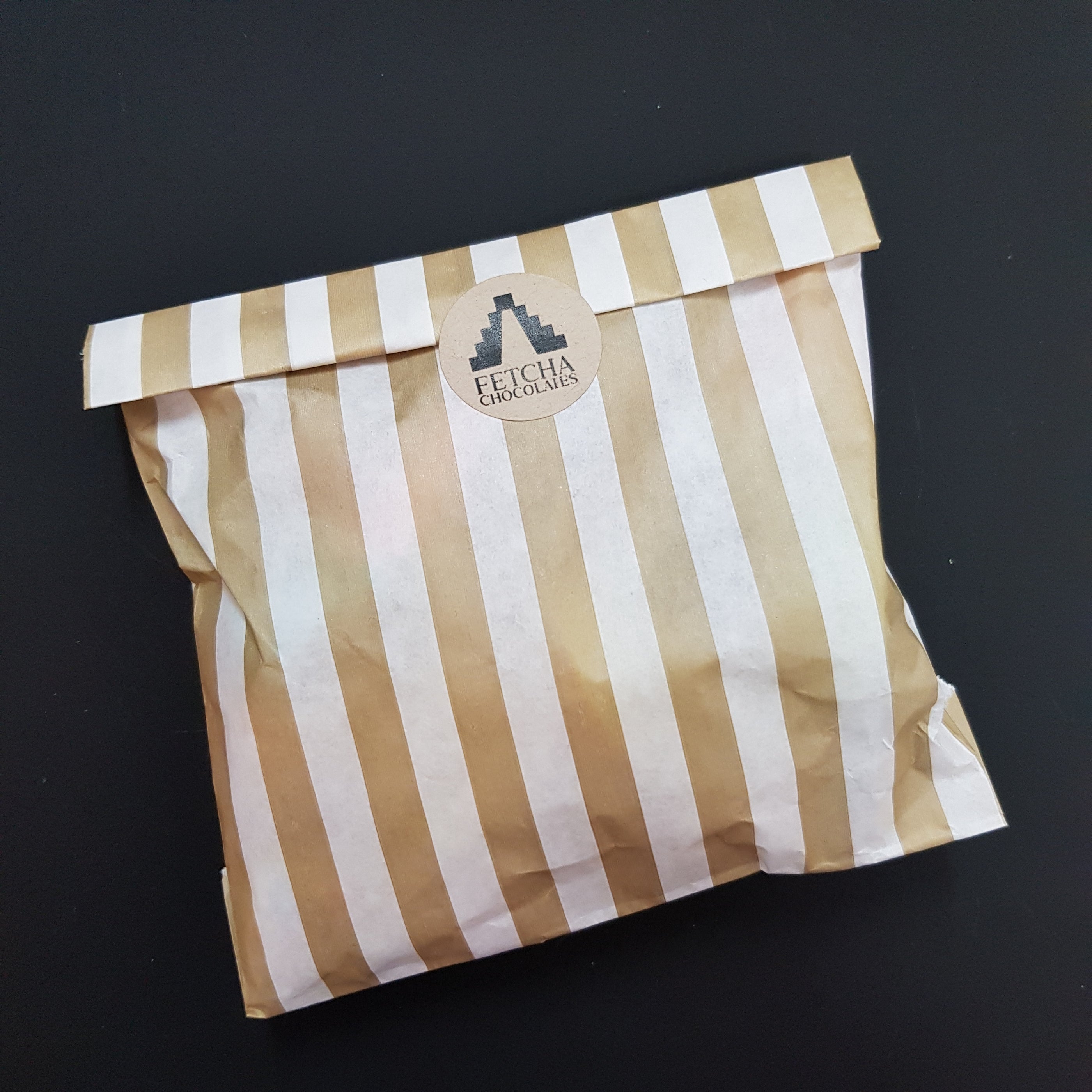 Image shows a striped paper bag being used a plastic-free packaging for turkish delight being sold by Fetcha Chocolates