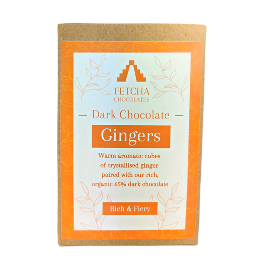 Image shows Fetcha Chocolates handmade dark chocolate gingers,  which are vegan, dairy free, gluten free and soy free and come in plastic-free packaging. The packaging is brown kraft cardboard with an orange label. 
