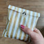 Image shows a hand holding a stiped paper bag as the packaging for jelly bean heart sweets being osld by Fetcha Chocolates