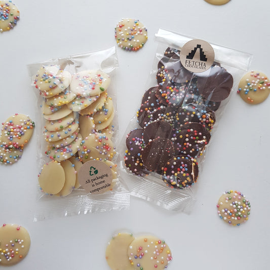 Image shows Fetcha Chocolates handmade white and milk chocolate jazzies, which are vegan, dairy free, gluten free and soy free and come in plastic-free packaging. 